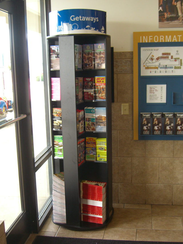 a rotating brochure rack in a visitor center lobby by the door